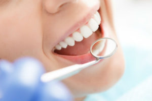 A woman holding a tooth brush in her mouth.