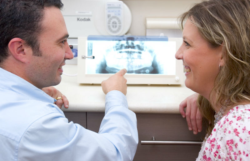 A man and woman talking to each other in front of an x-ray.