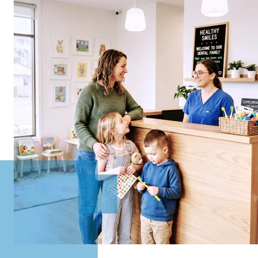A family with two children visits a dentist's office reception