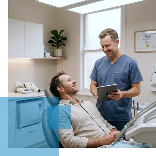 Dentist consulting a smiling male patient in a modern dental office