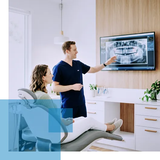 Dentist explaining dental X-ray to patient in modern clinic setting